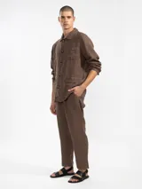 Chaqueta marrón de lino italiano, de corte relajado, con tres bolsillos frontales y cierre con botones.