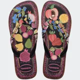 Ojotas Havaianas Top Tropicalia Vibes II, color negro con estampado de frutas tropicales y borde con patrón étnico. Las tiras son negras con el logo de Havaianas en dorado.