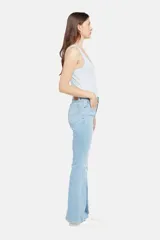 Pantalón de jean celeste con corte flare y diseño de parches en diferentes tonos de azul.