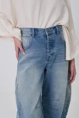 Pantalón de jean gris oscuro, de corte barrel, con bolsillos laterales y traseros, pinzas y tiro medio.