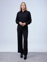 Pantalón negro de pierna ancha, marca Zac & Rachel. Pretina ancha con aplique de botones y bolsillos simulados con tachas.