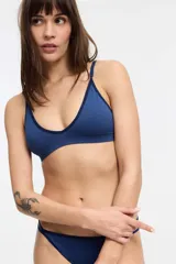 Bralette blanco de microfibra seamless con escote en V y diseño de olas. Sin copa ni aro, con breteles ajustables y cierre trasero de tres posiciones.
