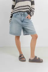 Bermuda de jean celeste con corte relajado, ruedo desflecado y diseño clásico de cinco bolsillos.