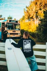 Buzo negro de manga larga con estampa en la espalda con una foto en blanco y negro de una ola y el logo de la marca Glassy.