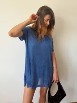 Vestido corto azul con brillo sutil, de tejido liviano y caída fluida. Cuenta con forro interno, mangas cortas y tajos laterales.