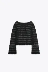 Jersey corto de punto calado negro, con cuello redondo amplio y mangas largas acampanadas.