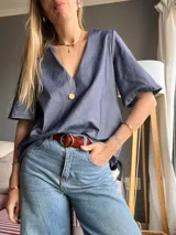Blusa celeste de denim con escote en V y mangas cortas amplias.