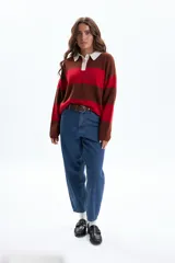 Sweater de tejido de punto con diseño a rayas horizontales anchas en colores rojo, marrón oscuro y beige claro en el cuello. Posee cuello polo y tapeta con botones.