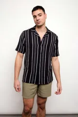Camisa negra con rayas verticales plateadas, de manga corta y cuello americano.