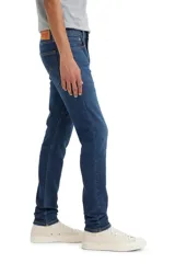 Pantalón de jean azul oscuro, corte skinny taper, con tiro medio y confeccionado en tejido stretch.
