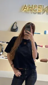 Remera negra de algodón con corte cuadrado, cuello redondo y logo bordado en color naranja.