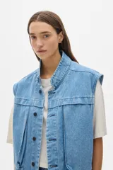 Chaleco de jean celeste con corte vintage y amplios bolsillos delanteros.