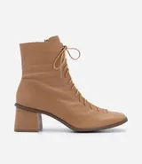 Bota de cuero color marrón claro, de caña media, con puntera cuadrada, taco bloque y cierre con cordones y cremallera.