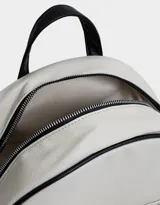 Mochila negra de cuerina con correas regulables, manija superior, cierre superior con doble deslizador, bolsillo frontal con cierre y deslizador, etiqueta metálica y bolsillos laterales.