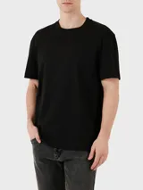 Remera negra de algodón con cuello redondo y mangas cortas. Tiene un pequeño logo de Calvin Klein en el pecho.