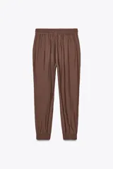 Pantalón jogger marrón de tiro alto con cintura elástica ajustable con cordones, bolsillos delanteros y puños elásticos en los tobillos.