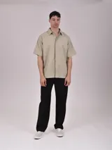 Camisa verde de manga corta con cuello clásico y cierre frontal con botones.