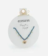 Collar corto con cuentas azules y colgantes dorados en forma de gota. Dije central con forma de ojo turco con detalles dorados y cristal azul.