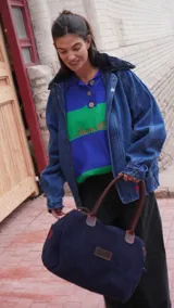 Bolso de viaje color verde oliva con detalles en cuero marrón.