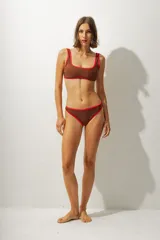 Top de bikini marrón con contorno rojo y breteles finos.