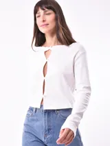 Remera manga larga color blanco con escote con abertura y lazos.