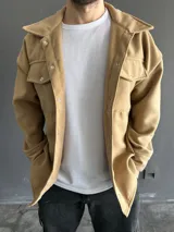 Chaqueta tipo camisa de paño color camel con cuello clásico, cierre frontal con botones a presión y bolsillos de parche con solapa en el pecho.
