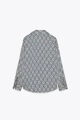 Camisa de manga larga con cuello solapa y estampado geométrico en tonos azul marino y blanco.