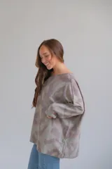 Sweater oversized de cuello redondo, manga larga caída y estampado animal abstracto en tonos verde y gris.