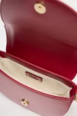 Bolso bandolera rígido color rojo, con asa corta y correa larga de tejido tipo canvas. Cierre con solapa e imán y bolsillo interior con cremallera.