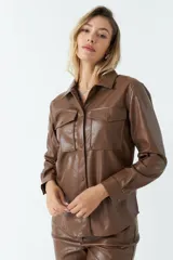 Sobrecamisa color beige de efecto cuero, con cuello clásico, cierre frontal con botones a tono, mangas largas con puños abotonados, dos bolsillos con solapa en el pecho y corte recto.