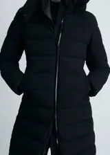 Abrigo largo acolchado negro con capucha, cierre frontal con cremallera, dos bolsillos laterales y puños elásticos.