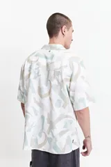Camisa de manga corta con cuello pijama y estampado abstracto en tonos celeste, beige y blanco.