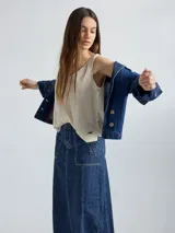 Campera de jean azul con cuello y solapa, corte entallado y largo a la cintura.