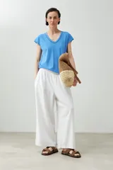 Remera color durazno con escote en V y detalle de trenza en el borde.