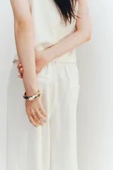 Pantalón culotte color blanco hueso, de tiro alto con cintura elástica, corte amplio y bolsillos laterales.