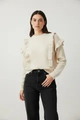 Sweater de poliamida color natural, con cuello redondo a la base, volados en los hombros y corte al cuerpo.