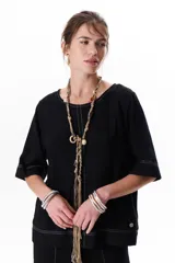 Blusa de lino color beige claro, con mangas 3/4 y cuello redondo. Presenta pespuntes a contratono en el centro, puños y ruedo.