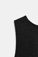 Top negro sin mangas, de cuello redondo, con tejido texturizado o estructurado.
