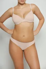 Conjunto de lencería color piel, compuesto por un corpiño con aro y breteles regulables, y una bombacha tipo tanga.