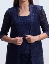 Conjunto de pantalón, blusa y chaqueta de encaje azul marino, marca RM Richards. La blusa es de encaje con escote redondo. El pantalón es de seda fría con cintura elastizada. La chaqueta es de encaje con mangas 3/4.