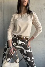 Remera beige de manga larga con cuello redondo y bordado floral en el escote.