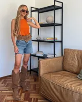 Bota alta de cuero color beige, estilo texana, con caña alta y taco bajo.