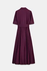 Vestido camisero midi color morado oscuro, con cuello solapa, manga corta y bolsillos de plastrón con solapa en el pecho. Incluye un cinturón ancho del mismo tejido anudado a la cintura.