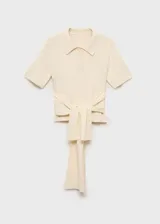 Jersey de punto fino color crudo, con cuello polo, cierre delantero con botones y detalle de nudo en la cintura.