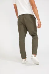 Pantalón cargo verde oliva de corte slim, con cierre de botón y cremallera, bolsillos laterales tipo cargo con cierre y sin puños.