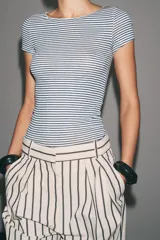 Camiseta de algodón a rayas horizontales azules y blancas, de corte ajustado, cuello barco y manga corta.
