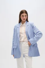 Blazer celeste con rayas verticales blancas, de lino, con cuello solapa y bolsillos frontales.