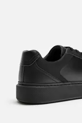 Zapatilla de cordones monocolor negra con suela con volumen.