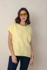 Blusa italiana color celeste con bordado de plumas al tono en el frente, confeccionada en lino y algodón.