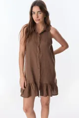 Vestido camisero marrón de lino, sin mangas, con cuello camisero, abotonadura frontal y ruedo con volantes.